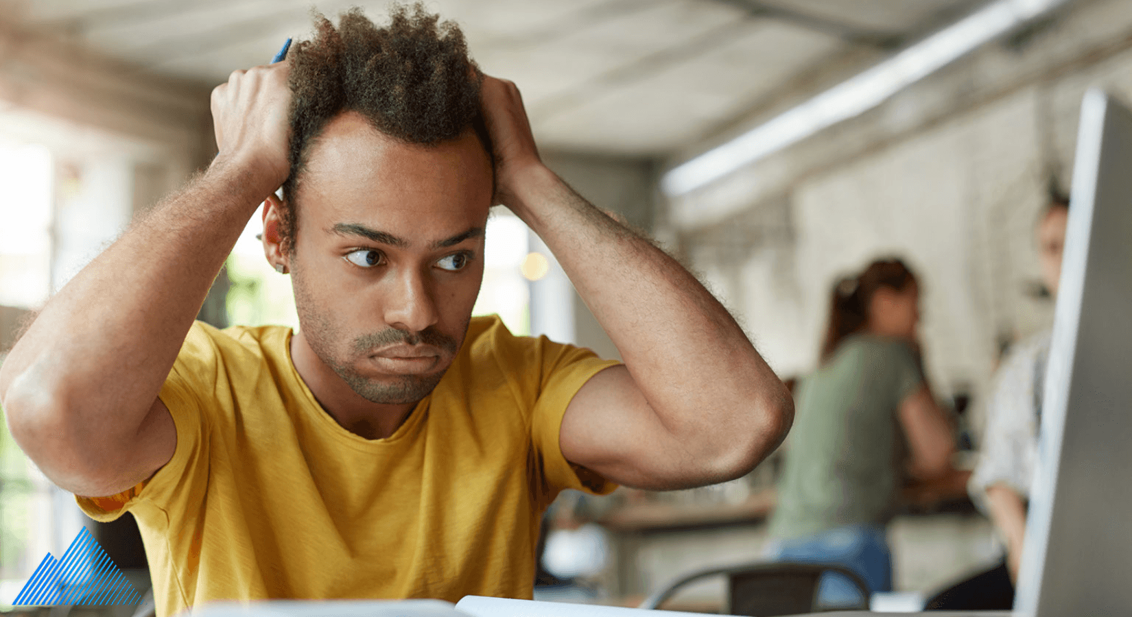 Frustrated person with hands in their hair looking at a laptop