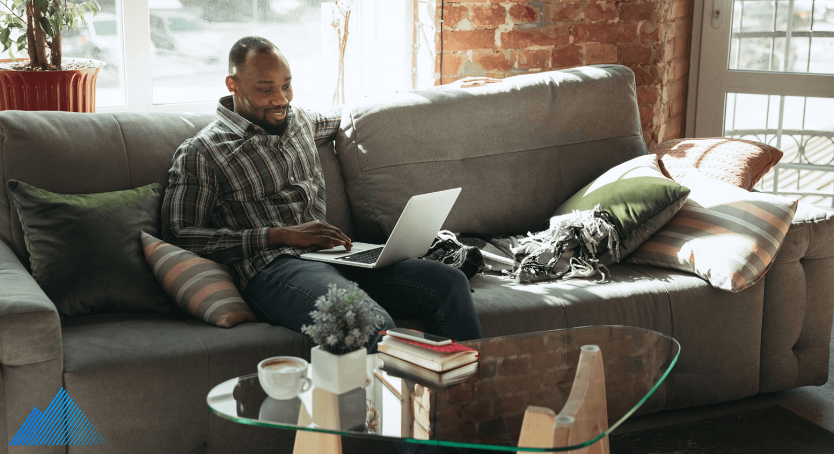 Man sitting on a couch using a laptop with Montavue Logo