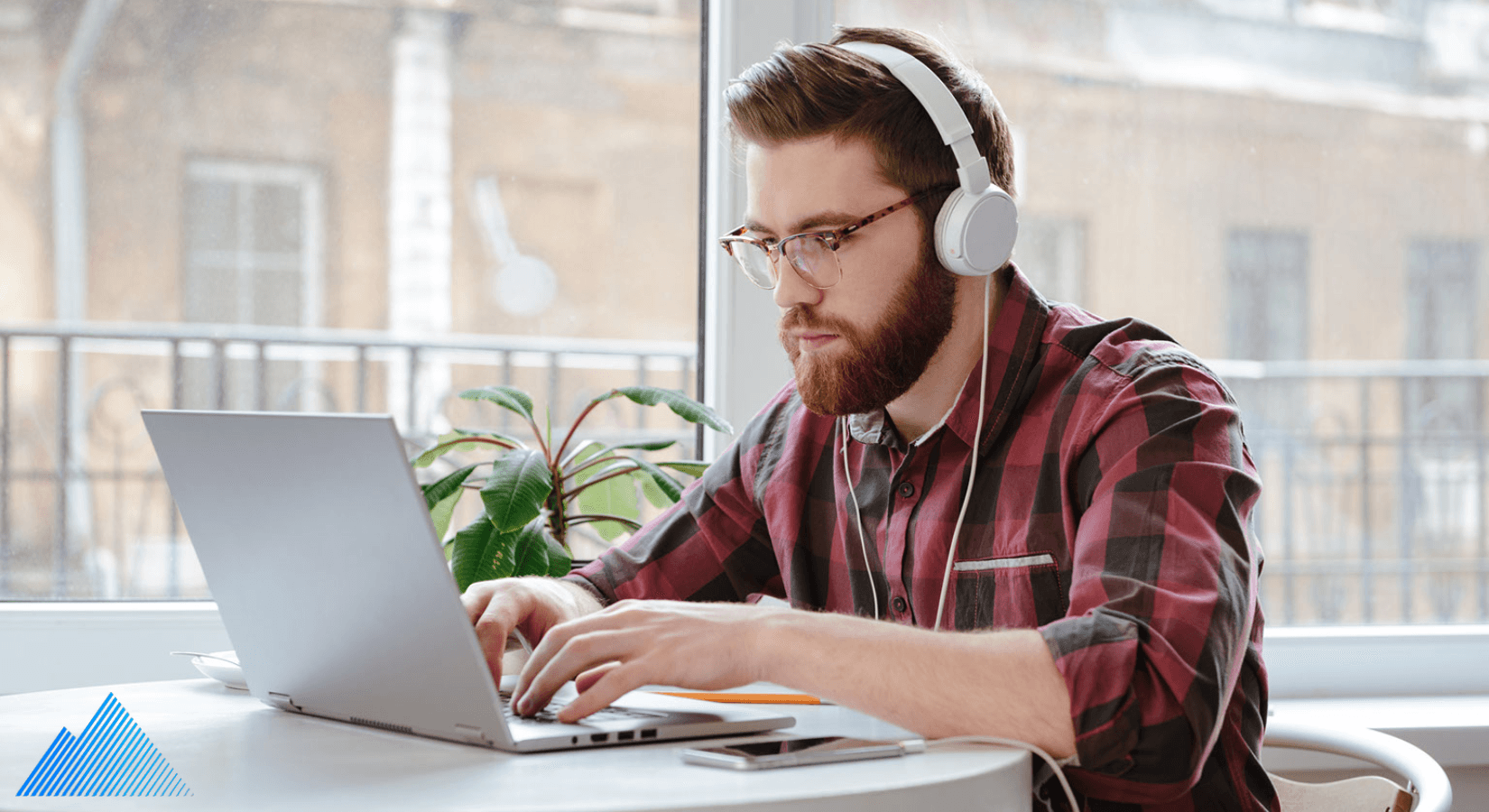 Man wearing headphones using a laptop