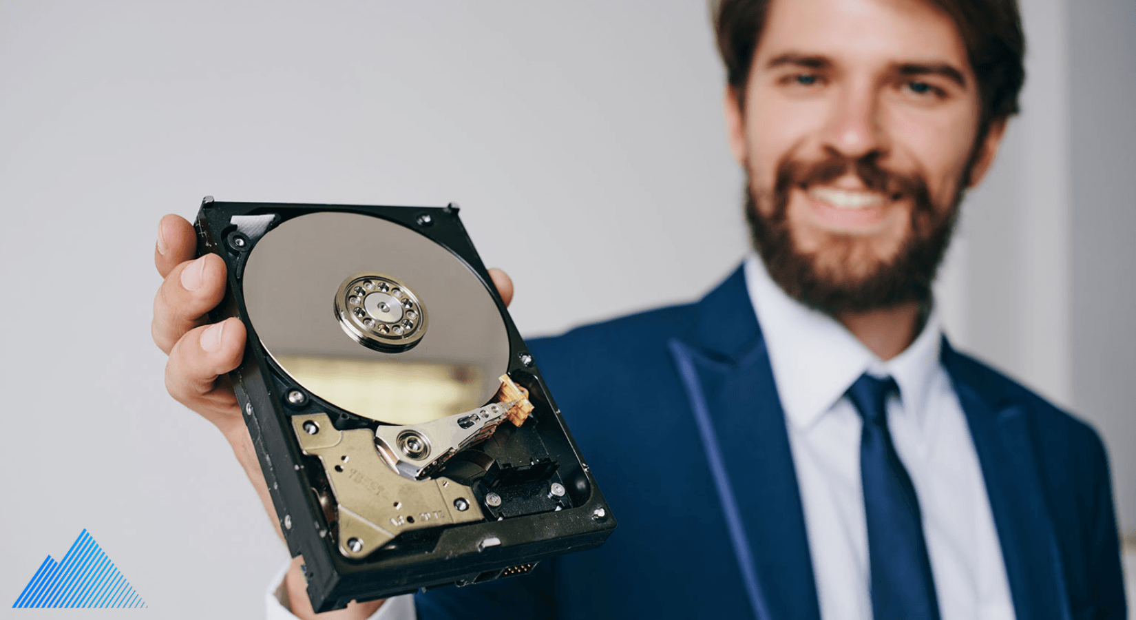 Man in a suit holding a hard drive