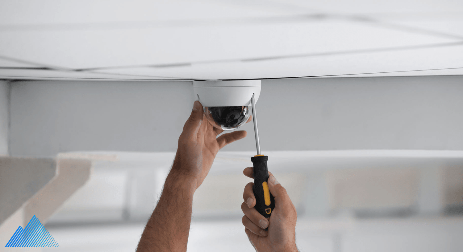 Person installing a dome security camera on the ceiling